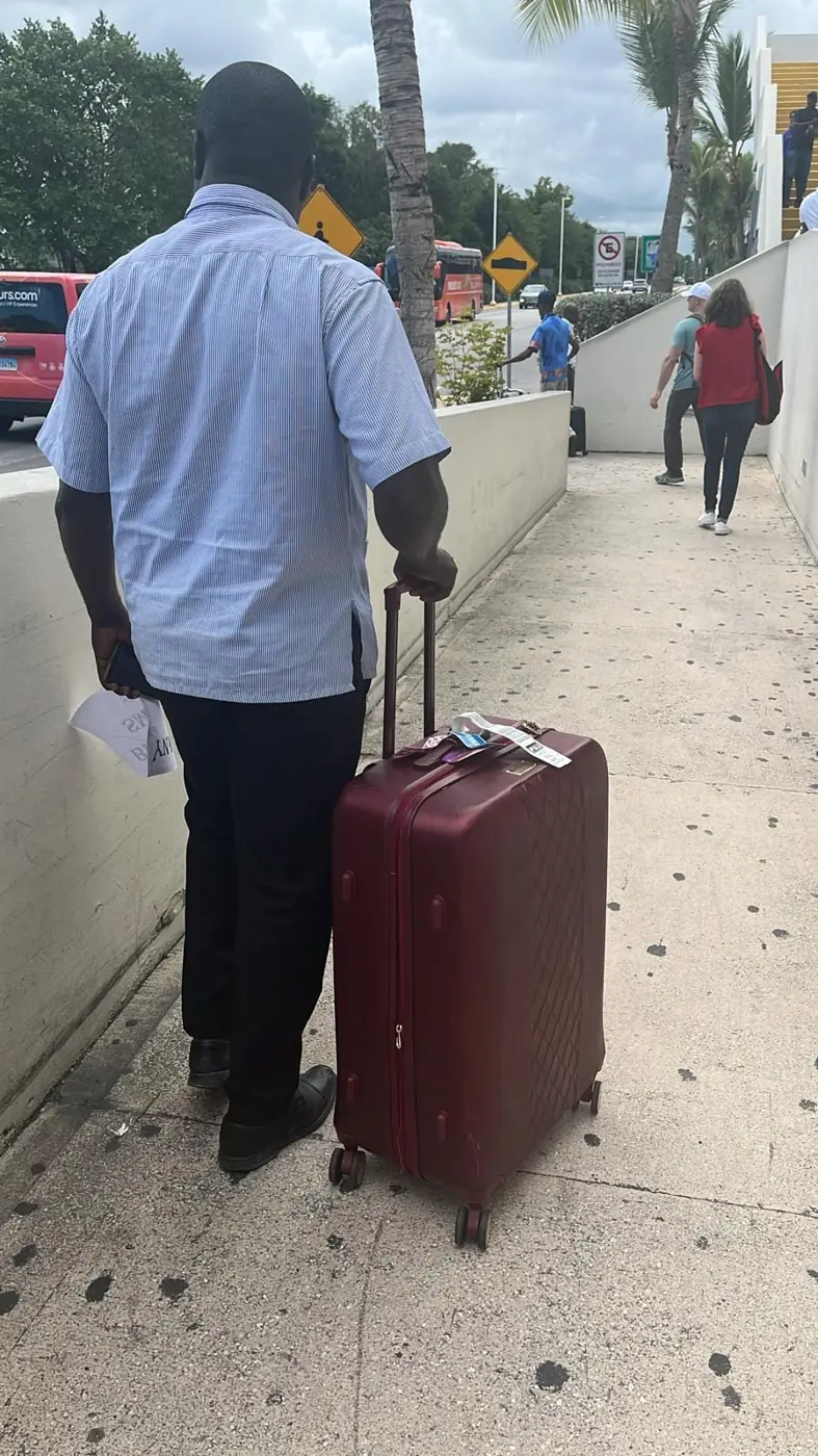 A traveler walking with his suitcase to the pickup point